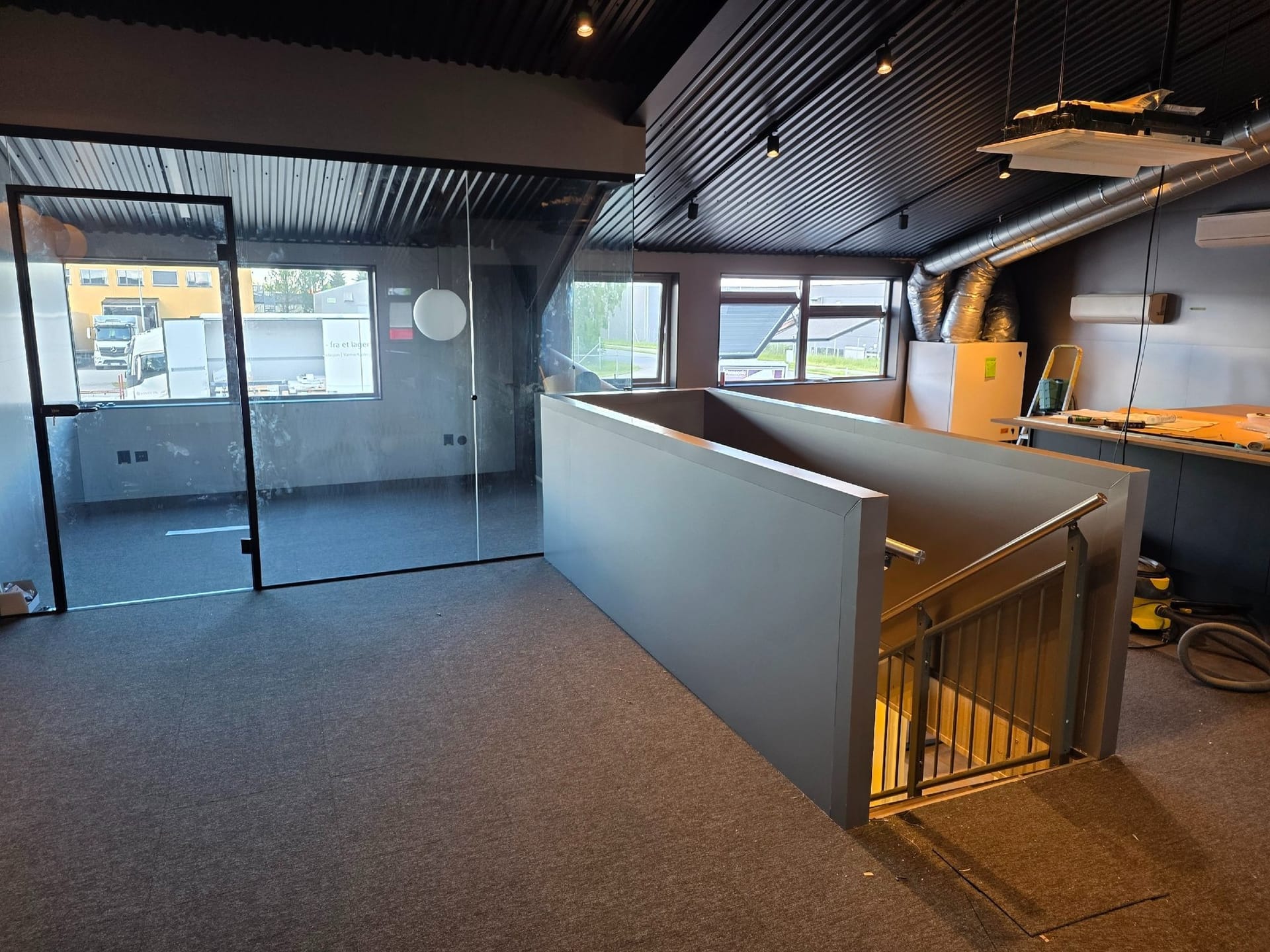 Åpent kontorlandskap med glassrekkverk